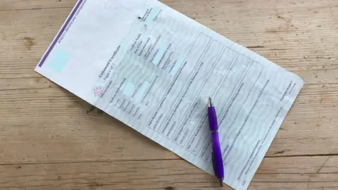 Martin Heath/BBC A redacted enhanced DBS check form on a table, with a purple pen placed on top