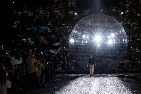 Andre Pain, EPA Designer Dries Van Noten walks towards giant disco ball paris fashion week