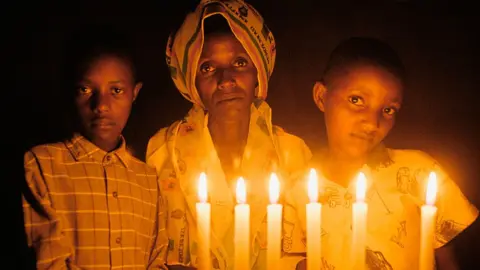 Getty Images Rwandan genocide rape survivor Marthe Mukandutiye (C) and her children pictured in 2004