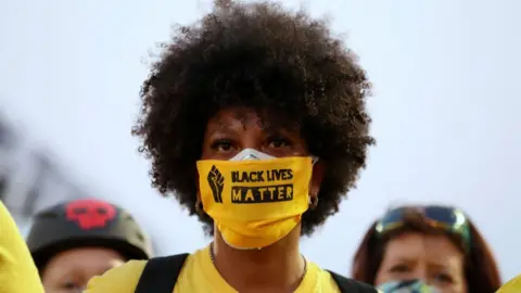 Reuters Protester in Portland with a face covering that says "Black Lives Matter" on it