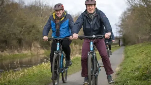 PA Media Ed Davey and Willie Rennie on bikes alongside the Union Canal in Edinburgh