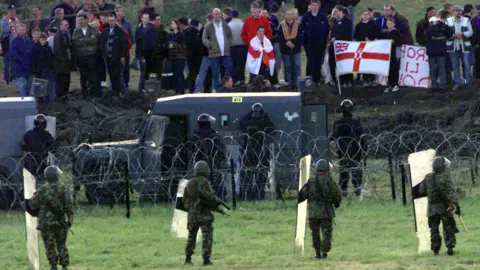 Pacemaker PACEMAKER BFST 10-07-98: Army and police confront the Orange protestors at Drumcree last night across the moat dug by the security forces. Violence flared for a third night with shots being fired at police lines.