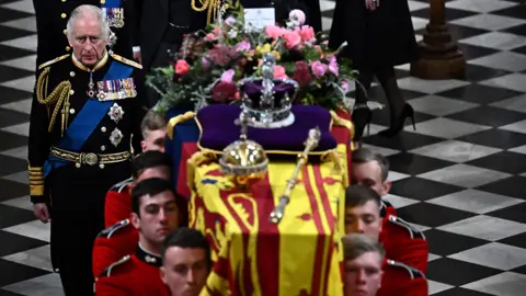 Getty Images King Charles III walks behind the coffin of Queen Elizabeth II as they leave Westminster Abbey in London on September 19, 2022