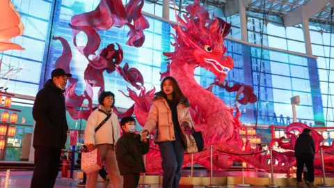 EPA People walk by a dragon lantern in a shopping centre in Beijing, China