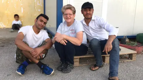 BBC Lisa Campbell sitting with residents of the Oinofyta camp