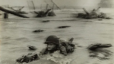 International Center of Photography/ Museum of Fine Arts, Boston Normandy invasion on D-Day, soldier advancing through surf, 1944 by Robert Capa