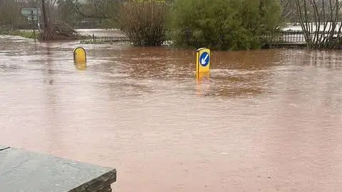 Connor Turner Flooded roads outside the Vine Tree pub in Crickhowell. You can see road sign markings sticking out from the middle of the road emphasising how the deep the water is. They are half covered.