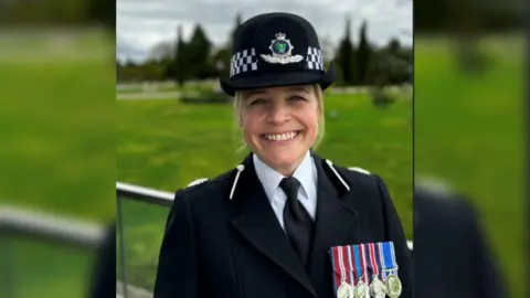 Gloucestershire Police A head shot of DCC Katy Barrow-Grint in police uniform with four medals on her lapel and smiling to camera