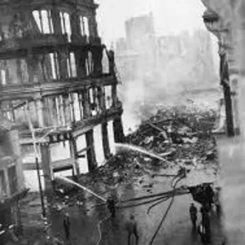 West Glamorgan Archive Service Black and white photograph of firemen extunguishing the fire which destroyed the Ben Evans department store in Swansea. Two fire hoses aiming water at the building. Much of Swansea's iconic architecture was destroyed during the Blitz