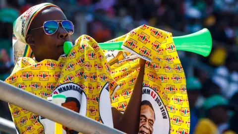 AFP A man blows a vuvuzela during the official inauguration ceremony of President Emmerson Mnangagwa in Harare, Zimbabwe - Sunday 26 August 2018