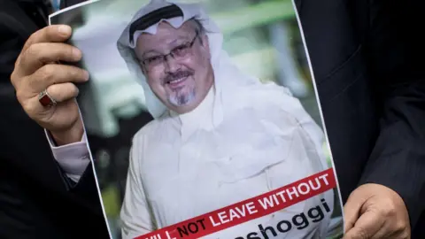 Getty Images A man holds a poster of Saudi journalist Jamal Khashoggi during a protest outside the Saudi consulate in Istanbul, 8 October 2018