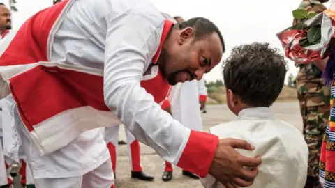 Getty Images Ethiopia's Prime Minister Abiy Ahmed (C) greets a child as he arrives to welcome Eritrea's President at the airport in Gondar, northern Ethiopia, on November 9, 2018