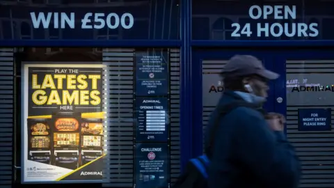 Getty Images A man walks past a casino advertising fixed odds betting terminals