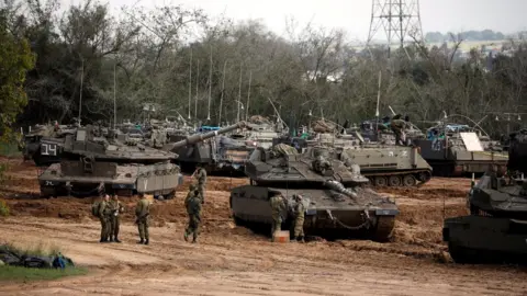 Reuters Israeli soldiers stand next to tanks and armoured personnel carriers near the border with Gaza (26 March 2019)