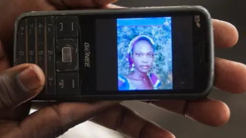 AFP Yana Galang, the mother of Rifkatu Galang, one of the abducted Chibok girls, holds a phone with a picture of her daughter during an interview in Lagos on 5 April 2016