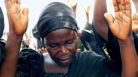AFP Bintu Bitrus, the mother of Godiya, one of the missing Chibok schoolgirls, weeps as she raises her hands along with other parents to pray for the release of their daughters kidnapped by Boko Haram jihadists, during a worship service to mark the fourth anniversay of the kidnapping at Chibok Town, Borno State, on April 14, 2018