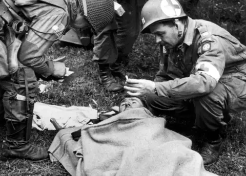 Getty Images A doctor of the US 82nd Airborne division cares for a wounded German prisoner in Normandy