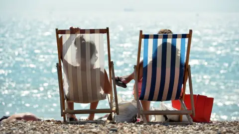 AFP Two people sit in deckchairs