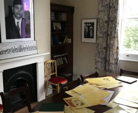 Photocopies of documents have been strewn across a table in Ambedkar House