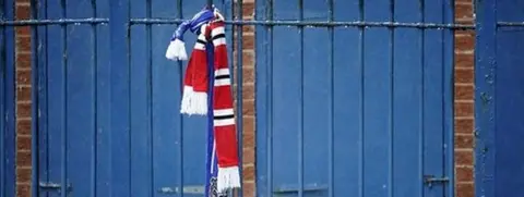 Getty Images Scarves tied to railings outside Bury's Gigg Lane stadium