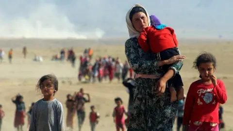 Reuters Iraqi Yazidis flee attacks by IS militants in the Sinjar region of Iraq (11 August 2014)