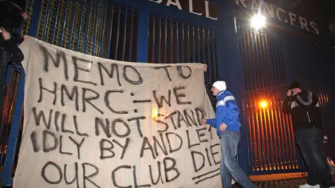Jeff J Mitchell Fans raise a banner on the gates of Ibrox Stadium on February 14, 2012 in Glasgow, Scotland