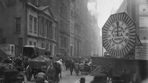 Getty Images Wagons trundle along Manhattan Streets past a YMCA clock sign