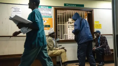 AFP Men wait for medicines at a pharmacy at Parirenyatwa Hospital in Harare, September 2019