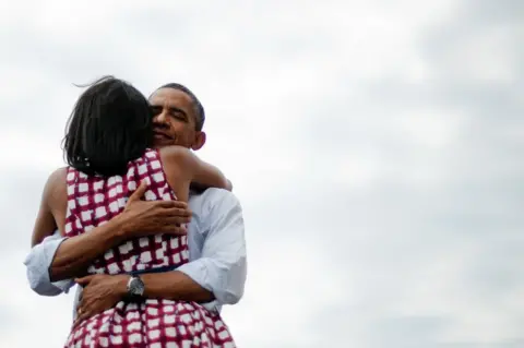 Getty Images Then US President Barack Obama hugs his wife Michelle Obama during his campaign tour on 15 August 2012