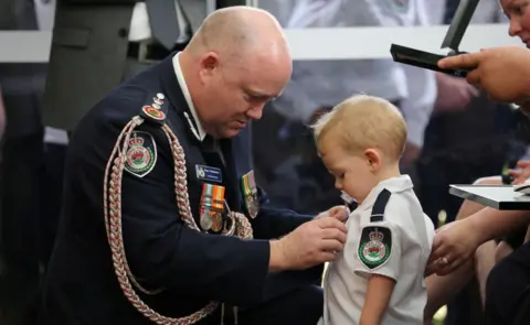 NSW RURAL FIRE SERVICE This photo of the commissioner and 19-month-old Harvey Keaton was widely shared online