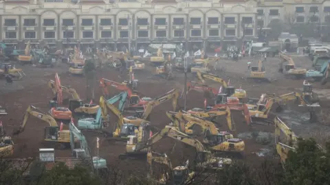 Getty Images Diggers on the site of the new hospital in Wuhan