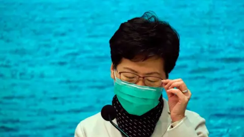 Reuters Carrie Lam wears a face mask at a press conference