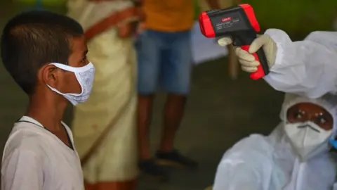 AFP Medical staff take the temperature of a child at a COVID-19 coronavirus community clinic