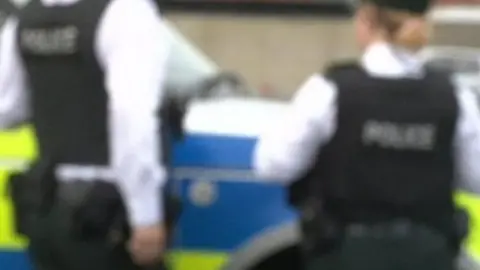 BBC A generic partially blurred image of two PSNI officers from behind