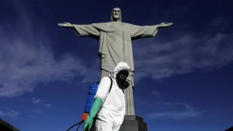 Reuters A worker wearing protective clothing stands in front of the Christ the Redeemer statue in Brazil
