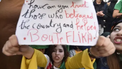 AFP An Algerian protester holds up a placard during an anti-government demonstration in the capital Algiers on 11 December 2019, ahead of the presidential vote.