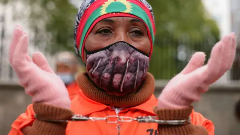 Getty Images Activists in prison jumpsuits and handcuffs protest human rights abuses against the Oromo people of Ethiopia at a demonstration opposite Downing Street on Whitehall in London, England, on October 10, 2020.