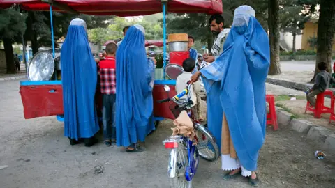 Getty Images Afghan man with his three wives in Kabul