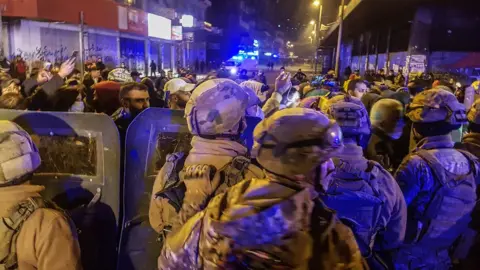 EPA Lebanese army soldiers stand in front of protesters in Tripoli, Lebanon (27 January 2021)