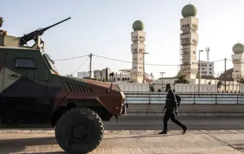 Getty Images A man walks past an army armoured personnel carrier (APC) in Dakar, Senegal - Monday 8 March 2021