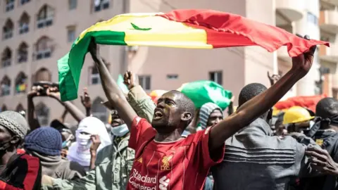Getty Images A supporter of main opposition candidate, Ousmane Sonko, reacts in protest outside the Justice Palace in Dakar, Senegal - Monday 8 March 2021
