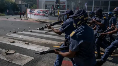 AFP A large group of South African Police Service (SAPS) officers disperse a group of students who were blocking roads during a protest in Braamfontein, Johannesburg, South Africa - Wednesday 10 March 2021