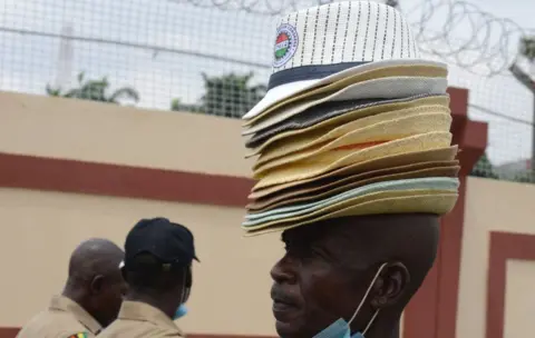 Getty Images A man hawks Labour Union caps at the entrance of Lagos State House of Assembly as members of Nigerian Labour Congress (NLC) and Trade Union Congress (TUC) hold a peaceful protest about the minimum wage in Lagos, Nigeria - Wednesday 10 March 2021