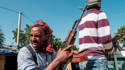 AFP Members of the Amhara militia ride in the back of a pick up truck, in Mai Kadra, Ethiopia, on November 21, 2020. - Amharas and Tigrayans were uneasy neighbours before the current fighting, with tension over land sparking violent clashes. That Mai-Kadra is now being run,at least temporarily, by Amharas provides relief to Amharas, even as it deepens Tigrayan fears of occupation. (Photo by EDUARDO SOTERAS / AFP) (Photo by EDUARDO SOTERAS/AFP via Getty Images)