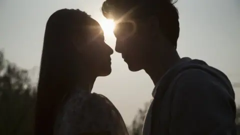 Getty Images A silhouette of a couple