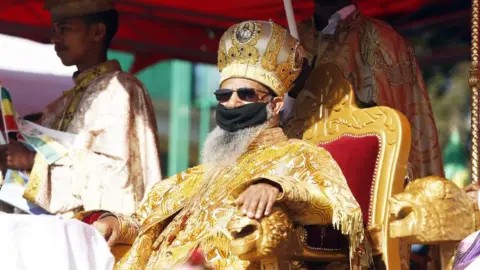 Getty Images Ethiopian patriarch of the Ethiopian Orthodox Tewahedo Church Abune Mathias attends the Timkat celebrations, which marks the Baptism of Jesus in the Jordan River, at Jan Meda Sports Field, in Addis Ababa, Ethiopia on January 19, 2021