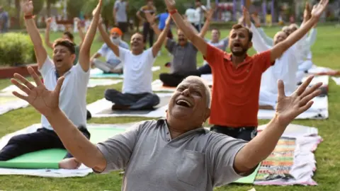 Getty Images Yoga practitioners exercise ahead of the International Yoga day at a park in Amritsar on June 19, 2021.