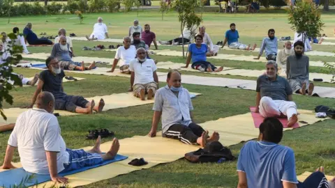 Getty Images People practice Yoga ahead of the International Yoga day in Lahore on June 20, 2021.