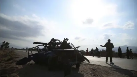 EPA Afghan security officials inspect the scene of a road side bomb blast that killed six civilians on the outskirts of Jalalabad, Afghanistan, 21 July 2021.