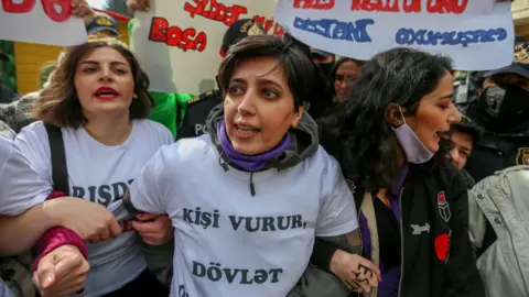 Getty Images Women in Azerbaijan link arms for International Women's Day.